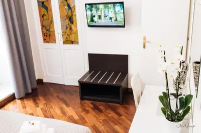 a living room with a bench and a tv on the wall at Magik rooms in Rome