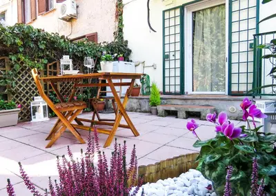 a patio with a wooden table and some flowers at Casa Sofia - beauty apartment close Vatican Museum in Rome