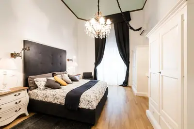 a bedroom with a large bed and a chandelier at Casa Prati Michelangelo in Rome