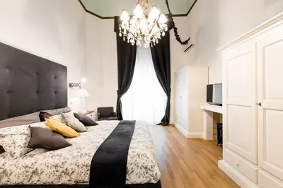 a bedroom with a large bed and a chandelier at Casa Prati Michelangelo in Rome