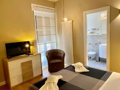 a bedroom with a bed and a television and a chair at Frattina Luxury House in Rome