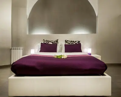 a large bed with purple sheets and purple pillows at Casa Calpurnia in Rome