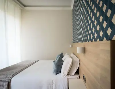a bedroom with a bed with white sheets and pillows at My Maison 109 Guest House in Rome