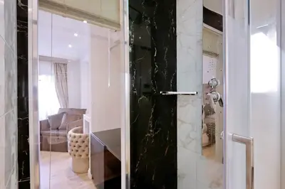 a bathroom with a glass door leading to a living room at Relais Aquarium in Rome