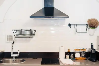 a kitchen counter with a sink and a hood at Restart Accommodations Celimontana in Rome