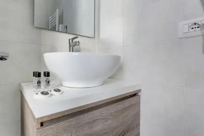a white bathroom with a sink and a mirror at Voyager House Termini - Home and More in Rome