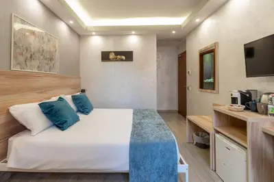 a bedroom with a large white bed with blue pillows at Drago D'Oro GUESTHOUSE - accross from metro Vittorio Emanuele in Rome