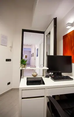 a desk with a computer on it with a mirror at Elements Guest House Roma in Rome