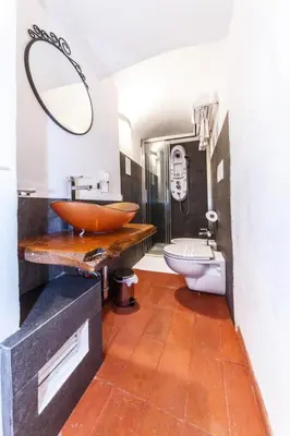 a bathroom with a bowl sink and a toilet at Rifugio degli Artisti B&B in Rome