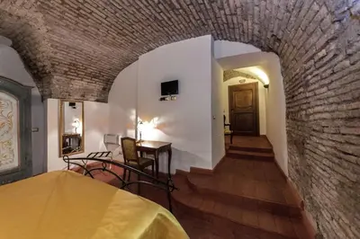 a room with a brick wall and a table and chairs at Rifugio degli Artisti B&B in Rome