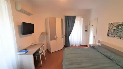 a room with a couch and a desk and a television at B&B Five in Rome