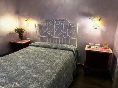 a bedroom with a bed and two end tables at Iris Guest House in Rome
