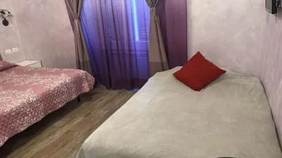 a bedroom with two beds and a red pillow at Iris Guest House in Rome