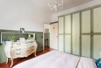 a bedroom with a bed and a dresser with a mirror at New Suite Amèlie in Rome
