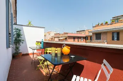 a balcony with a table and chairs on a roof at Appartamenti MarcoAurelio49 in Rome