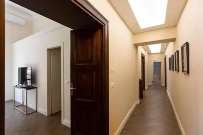 a hallway with a wooden door and a skylight at SPA Apartment Via Barberini in Rome