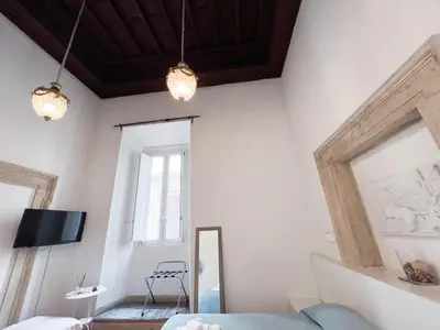 a living room with white walls and a blue couch at Flowers Apartments Rome City Center in Rome