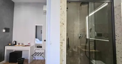 a bathroom with a shower with a glass door at AmoRoma Suite in Rome