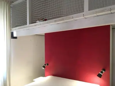 a bunk bed with a red wall and two lights at Gli Alberi a Testaccio in Rome