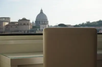 a white chair sitting in front of a window at Panoramic View of St. Peter in Rome