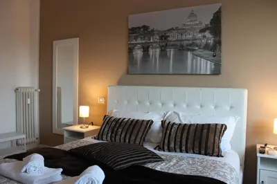 a bedroom with a large white bed with two pillows at Panoramic View of St. Peter in Rome