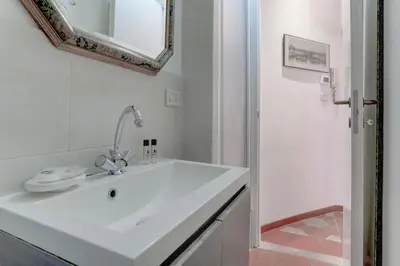a white bathroom with a sink and a mirror at Charming Colosseum in Rome