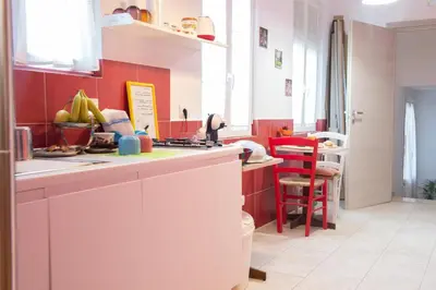 a kitchen with red walls and a white counter top at Da Merion in Rome