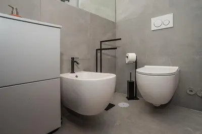a bathroom with a white toilet and a sink at LikeYourHome, 80 sq m luxury apartment with Jacuzzi, in Trastevere district in Rome