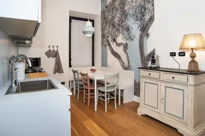 a kitchen with a table and chairs in a room at LikeYourHome, 80 sq m luxury apartment with Jacuzzi, in Trastevere district in Rome
