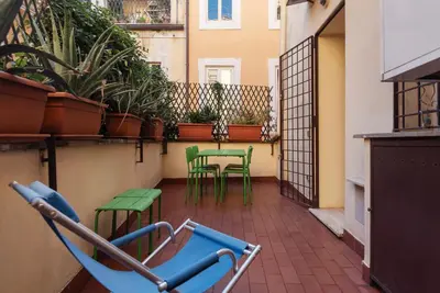a patio with chairs and tables on a balcony at Apartment with terrace near Piazza Navona - FromHometoRome in Rome