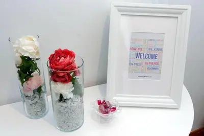 two vases with flowers sitting next to a framed picture at Colosseo Sunset Apartment in Rome