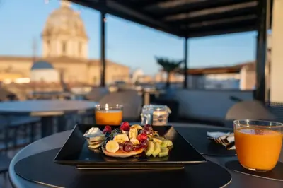 a plate of breakfast food on a table with orange juice at Campo de' Fiori 34 in Rome