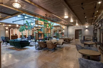 a lobby with tables and chairs and bookshelves at DoubleTree By Hilton Rome Monti in Rome