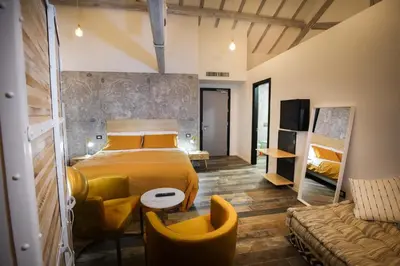 a bedroom with a yellow bed and a couch at Rosso Cortese in Rome