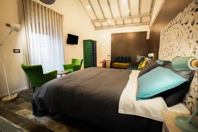 a bedroom with a large bed and green chairs at Rosso Cortese in Rome