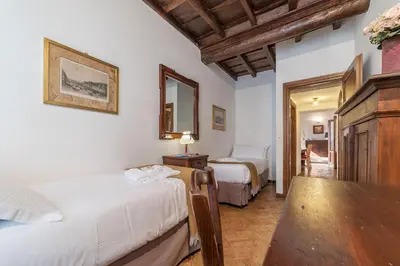 a bedroom with two beds and a mirror at By the charming Piazza Navona - FromHometoRome in Rome