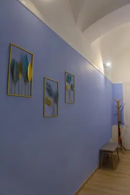 a blue wall with three paintings on it at Domus Vatican Museum in Rome