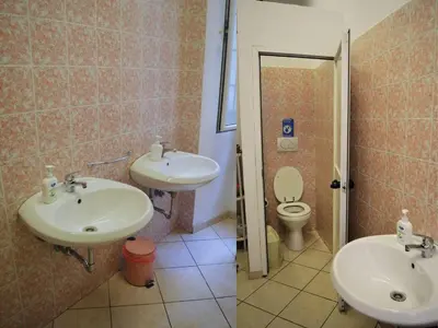 a bathroom with two sinks and a toilet at Ostello Marello in Rome