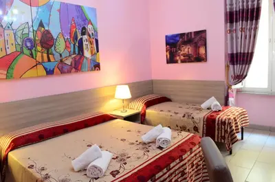 a room with two beds and a painting on the wall at Roma Castle Termini in Rome