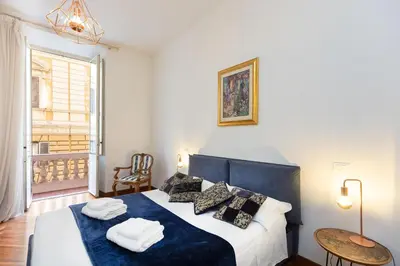 a bedroom with a large bed with blue sheets and pillows at TimeRoma in Rome
