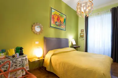 a bedroom with a bed and a table and a mirror at Vatican Rooms Irene in Rome