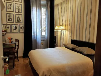 a bedroom with a bed and a desk and a window at Vatican Rooms Irene in Rome