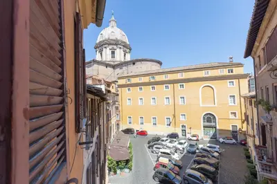 a view of a building with cars parked in a parking lot at DomusAmor Navona in Rome