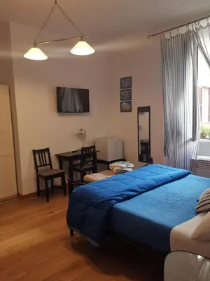 a bedroom with a blue bed and a table and chairs at Home 103 in Rome
