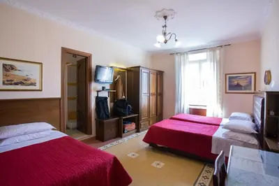 a hotel room with two beds and a television at Anthony Guesthouse in Rome