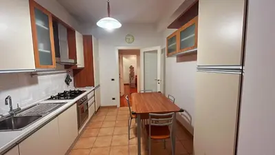 a kitchen with a table and a sink and a refrigerator at FG St Peter's Suites in Rome