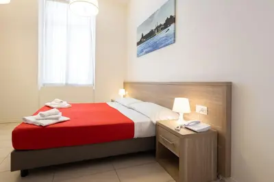 a bedroom with a large bed with a red blanket at San Luigi - Residenza Gemelli in Rome