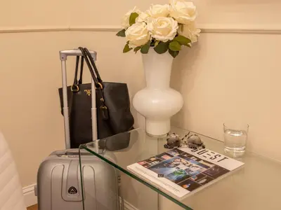 a glass table with a suitcase and a vase with flowers at Vatican Palace Suites by Premium Suites Collection in Rome