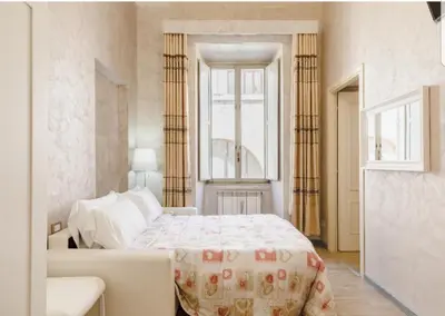 a white bedroom with a bed and a window at Rome Place in Rome