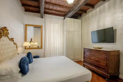a bedroom with a bed and a flat screen tv at Condotti Corner Apartment Piazza di Spagna in Rome